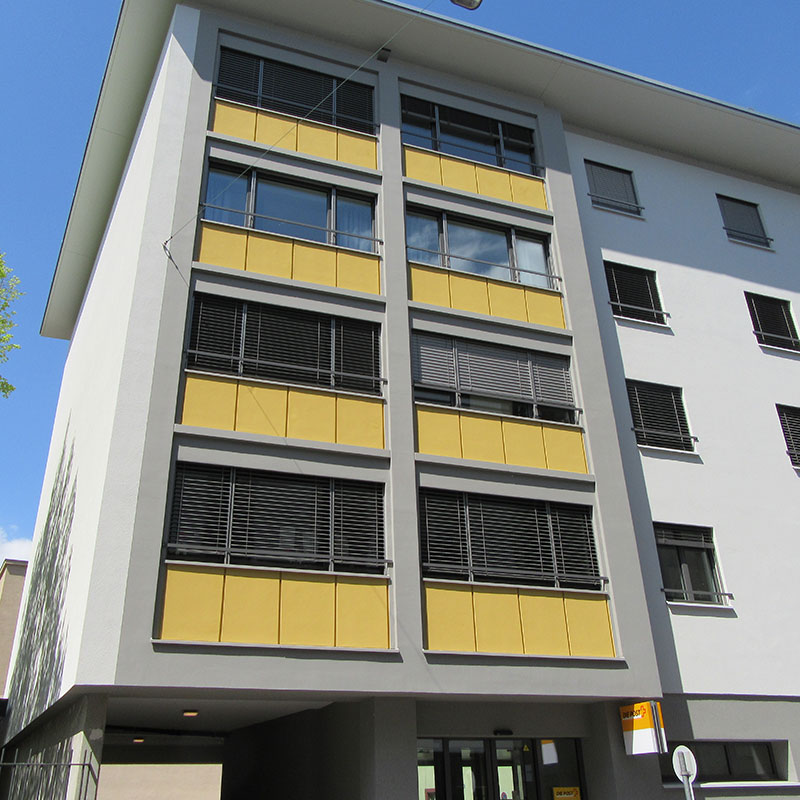 Ein Gebäude mit gelben und grauen Fenstern.