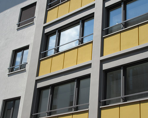 Ein lebendiges Gebäude mit gelben und weissen Fenstern